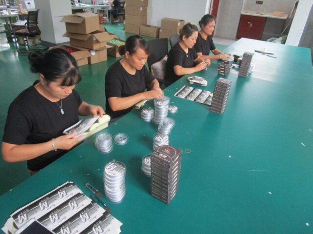 Workers packing fishing line spools into boxes